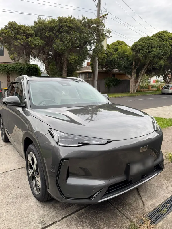 Grey Geely EX5 parked on a driveway, front three-quarter view after the detail